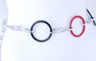 chain belt, red and black big circles alternating with triple oval silver links; alternating short smooth and long stippled twisted link extension chain with black circle at tip