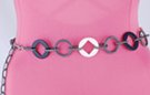 chain belt: black and white cartwheels joined by triple links of swirled pewter ring and chain links; extension chain comprises cross-hatched pewter chain links tipped by a tiny black ring