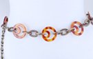 chain belt: eccentric amber rings joined by triple large flat oval antique gold chain links; extension chain comprises long stippled and short smooth twisted antique gold links tipped by tiny ball