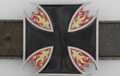 black belt buckle in shape of Maltese cross with flames