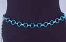 chain belt: smooth blue 7/8" rings joined by textured silver chain links; extension chain comprises very small textured oval and circle links tipped by tiny silver drop