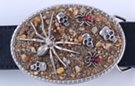 spiders and skulls belt buckle, nickel figures on desert sand background