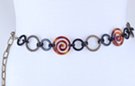 chain belt: amber spirals, black and swirled antique gold rings, all joined by double black circle links; extension formed of stippled antique gold chain links tipped by tiny ball