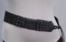 checker-board mesh of spherical beads interspersed with rows of oblong beads, double twine tie on either end